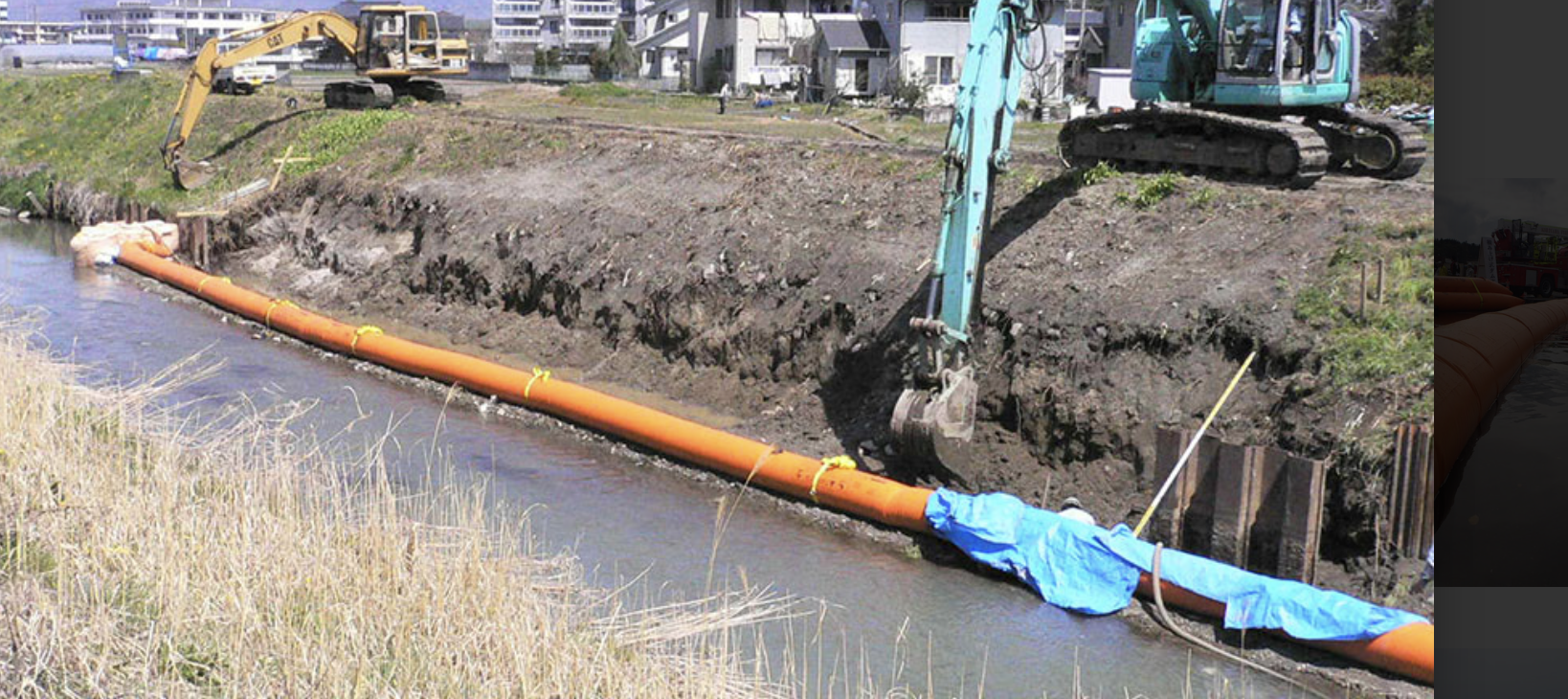 Tiger Dam™ deployed alongside excavator work — channel containment during embankment repair